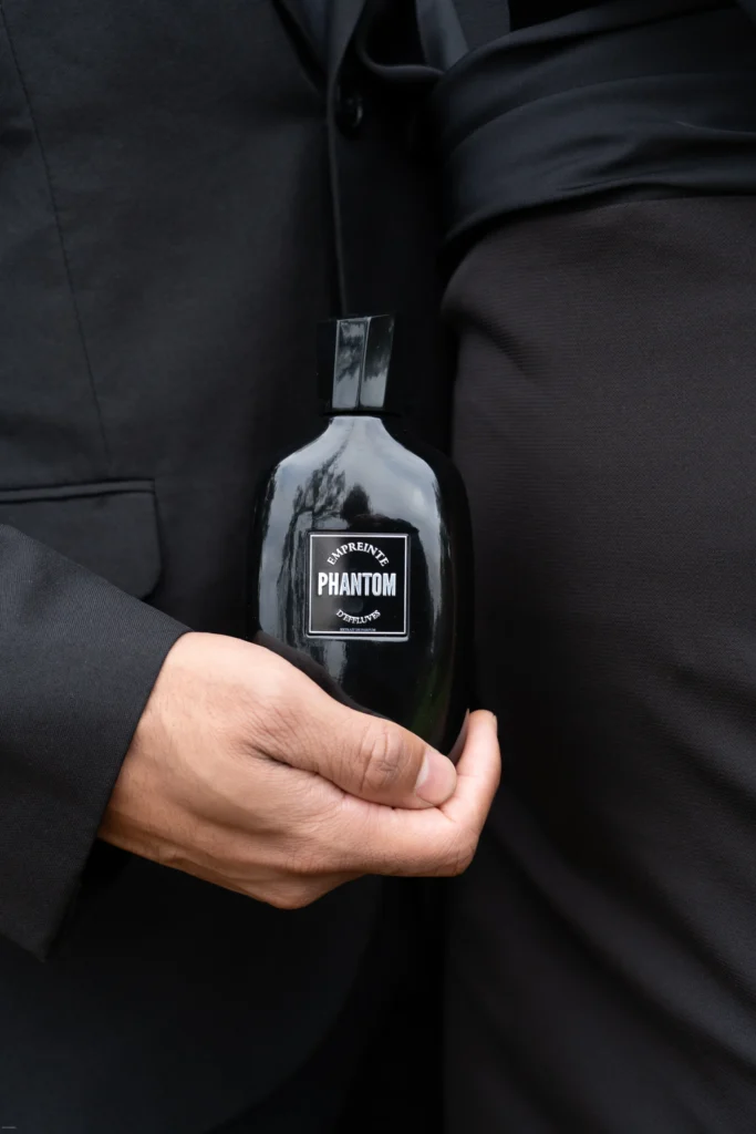 Flacon Phantom tenu contre un costume noir